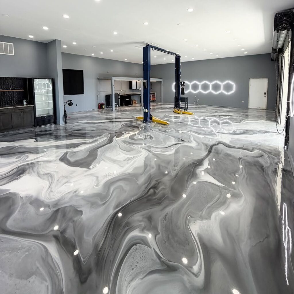 Marbled grey and white epoxy floor in a modern garage with a car lift.