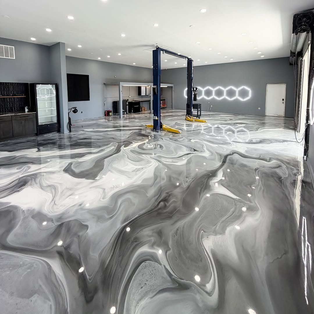 Marbled grey and white epoxy floor in a modern garage with a car lift.