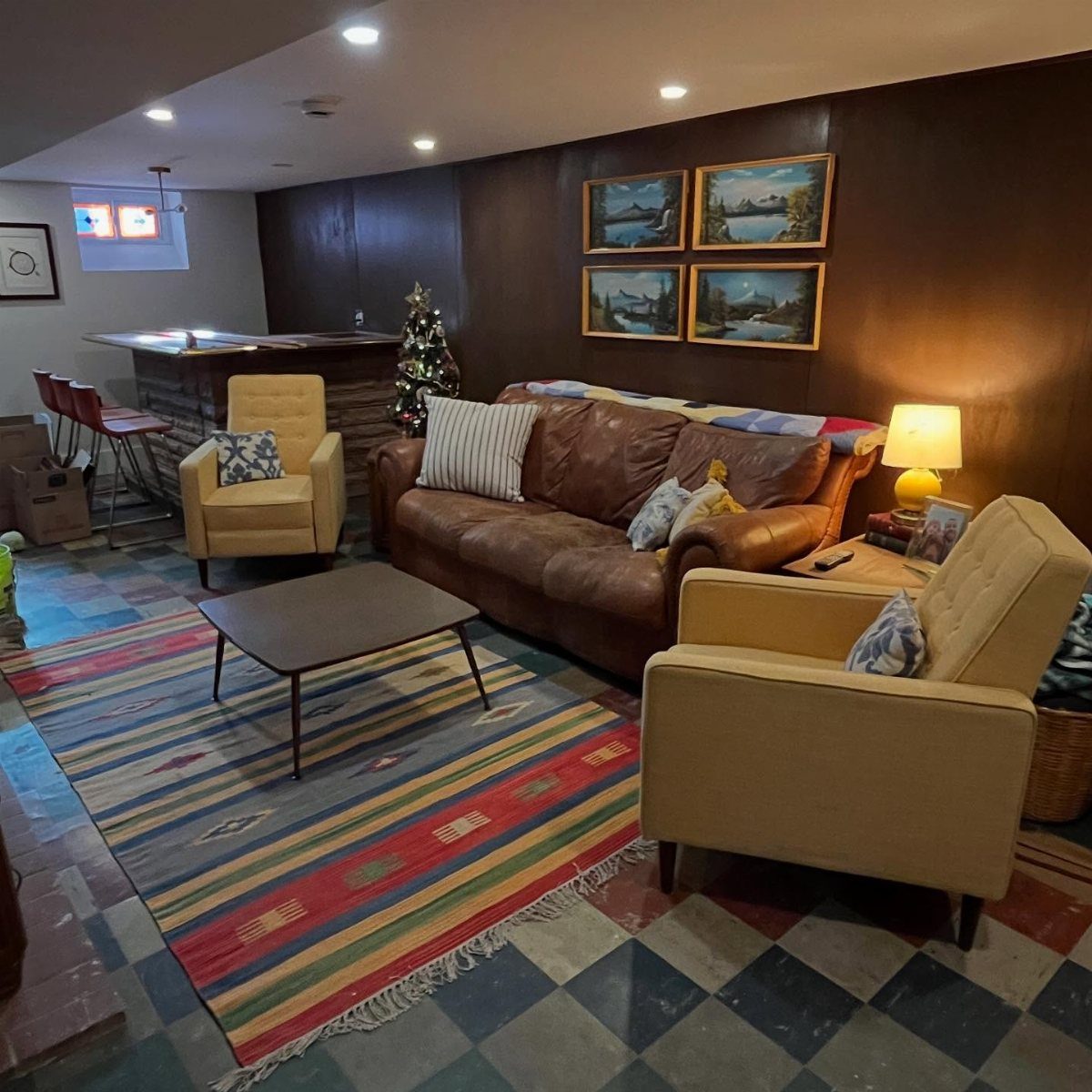 Dark brown wood paneled walls in a basement living room with leather furniture.