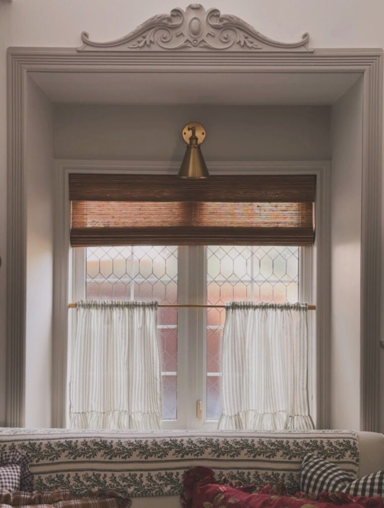 White cafe curtains on the lower half of a leaded glass window.