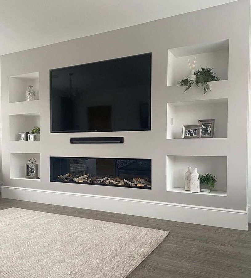 Modern grey entertainment wall with built-in shelving, flat-screen TV, and linear electric fireplace.