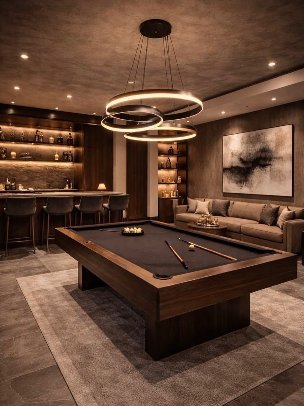 Luxury game room with a pool table and a home bar with stools.
