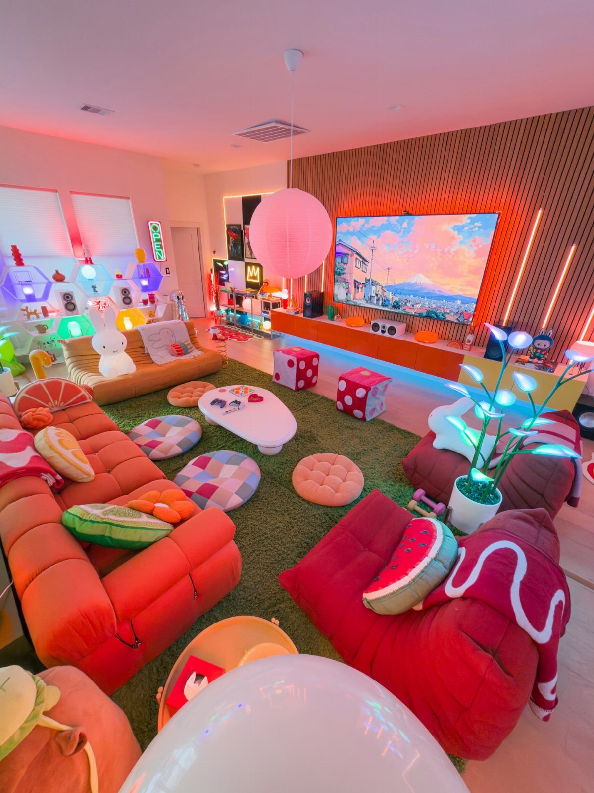 Vibrant game room with orange sofa, red bean bags, and colorful floor pillows.
