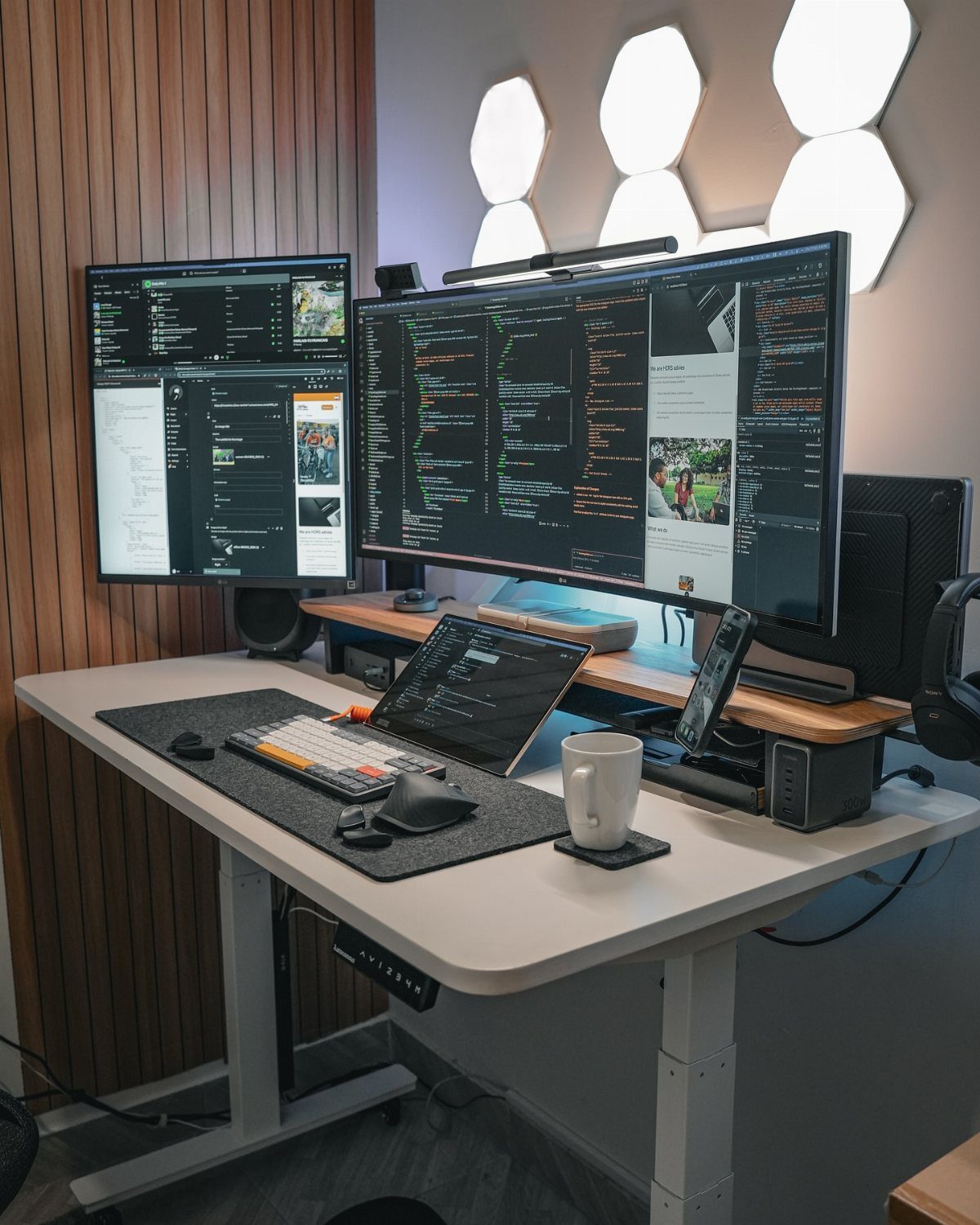 Modern home office desk setup with dual monitors, mechanical keyboard, and ambient lighting.