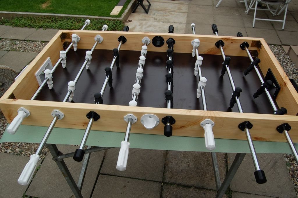 Homemade table football game made of wood and metal rods on a patio