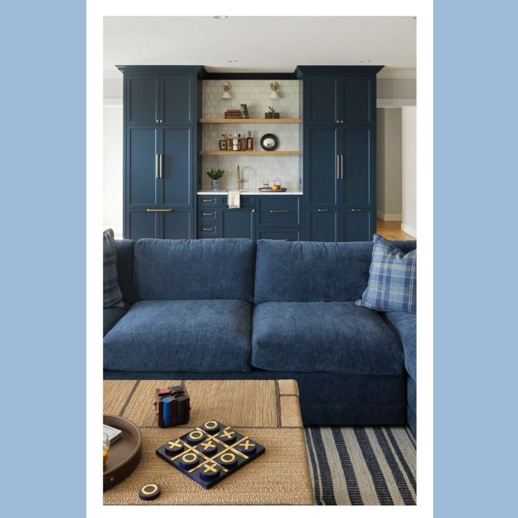 Blue sofa and woven coffee table in a room with blue built-in cabinets.